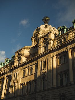 Capture of a historic building in England with rich architectural details bathed in warm sunlight.