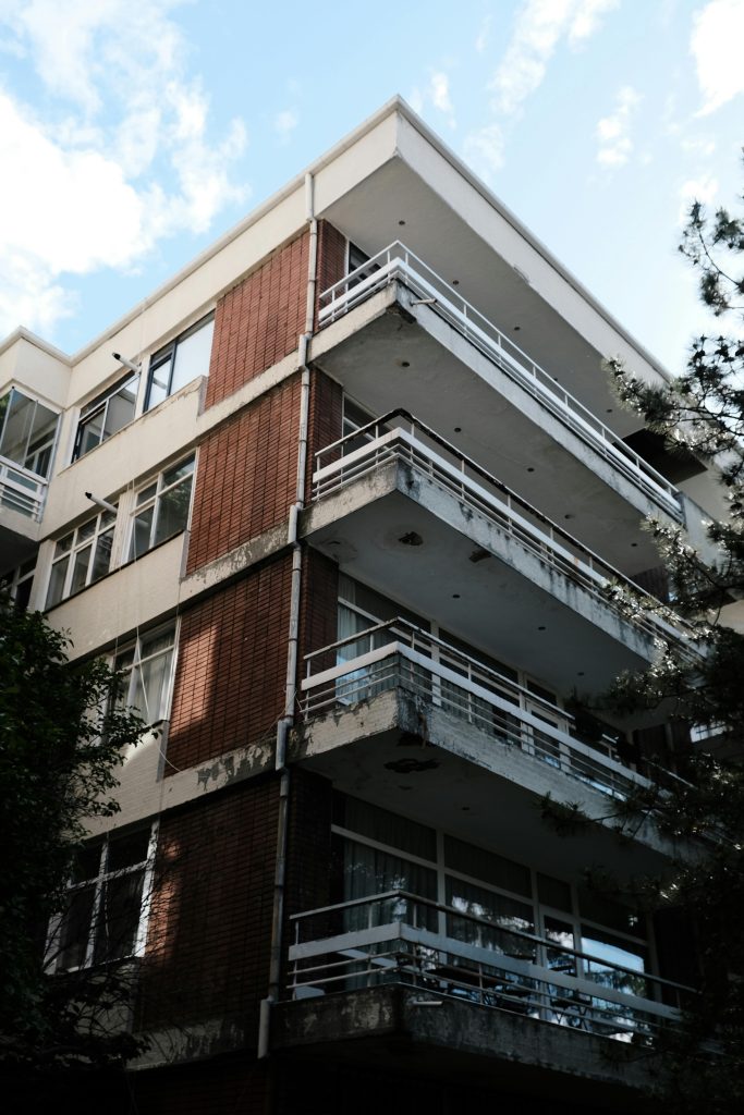 Corner view of a modern apartment building featuring multiple balconies.