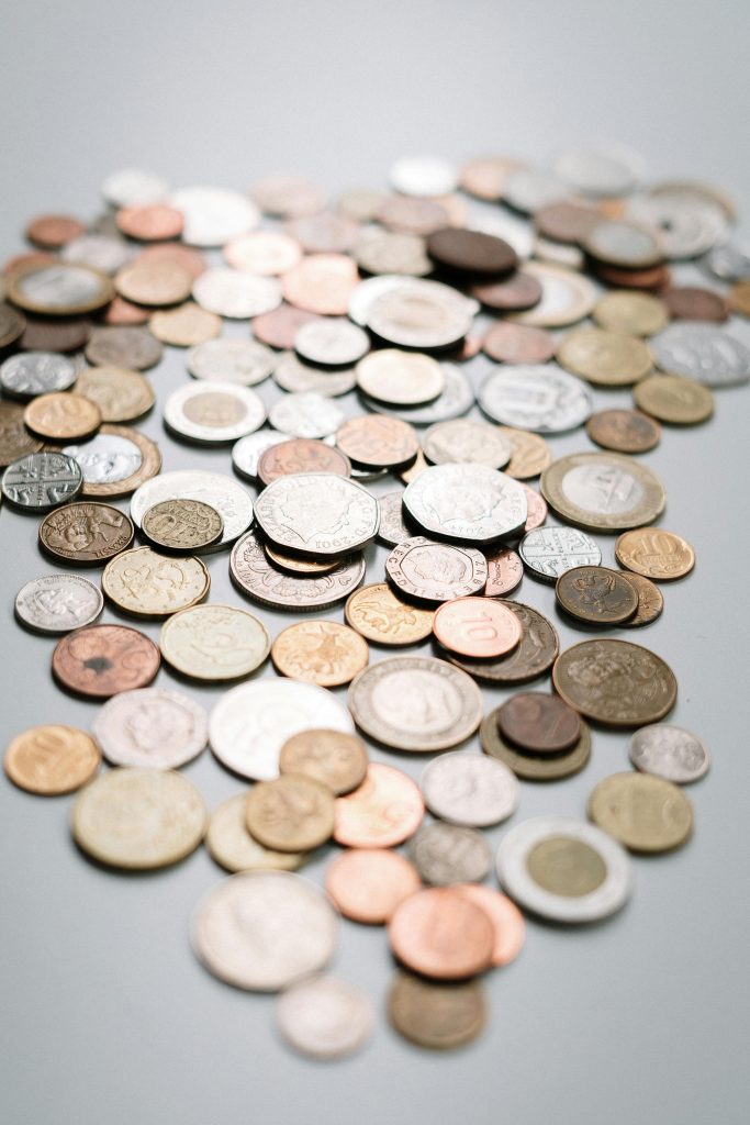 Close-up of scattered coins in various currencies, showcasing financial diversity.