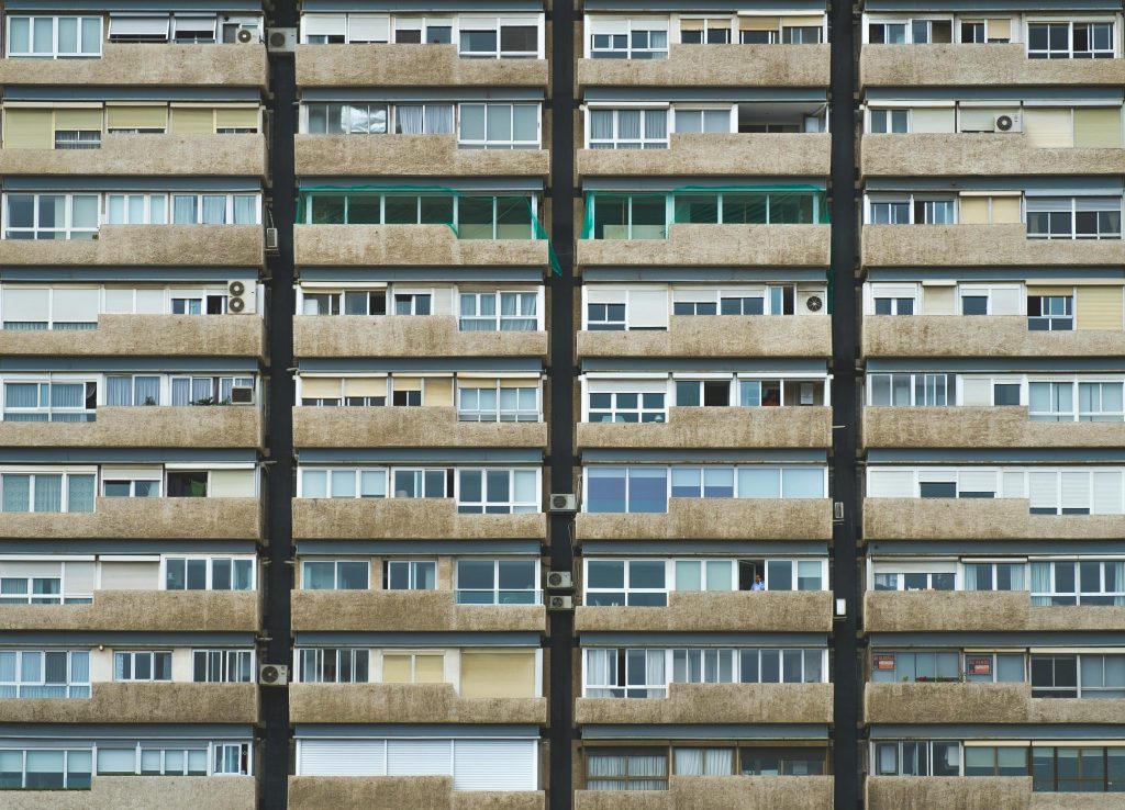 Symmetrical view of a residential building facade with balconies and windows in Valencia, Spain.