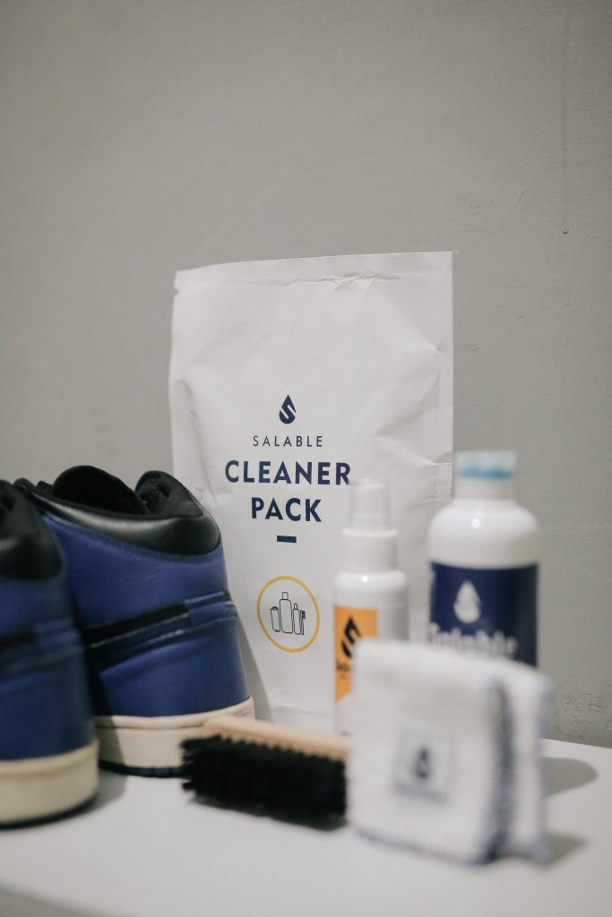 A comprehensive sneaker cleaning kit featuring a brush, cloth, and cleaning products for shoe care.